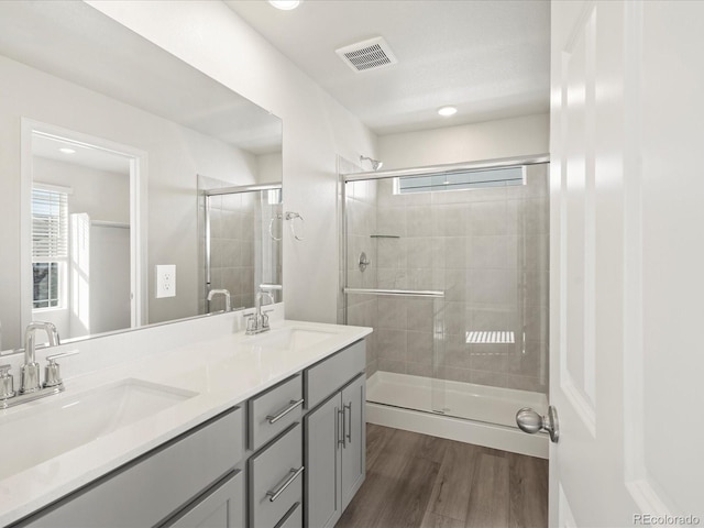 bathroom featuring hardwood / wood-style flooring, vanity, and walk in shower