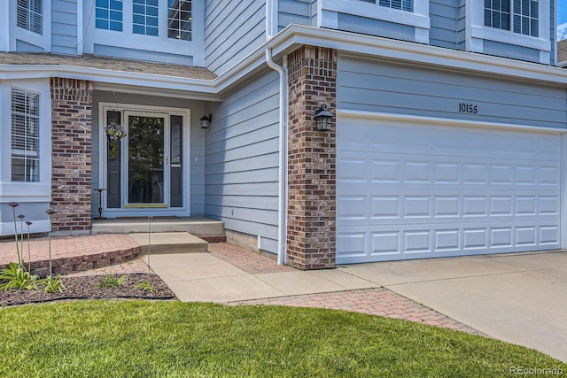 10155 Silver Maple Cir, Highlands Ranch, CO 80129 - doorway to property with a garage, brick siding, and driveway