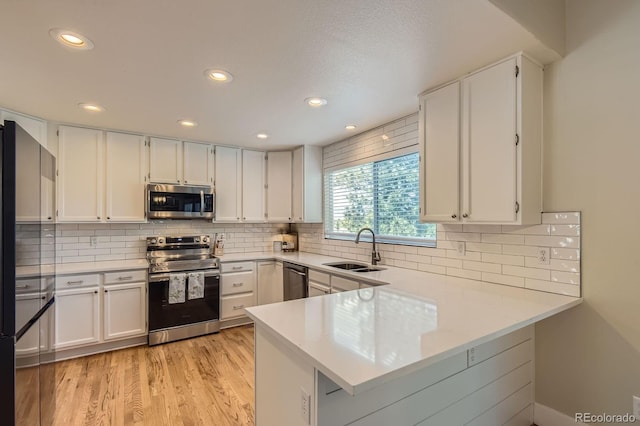 10155 Silver Maple Cir, Highlands Ranch, CO 80129 - kitchen featuring stainless steel appliances, a sink, a peninsula, light countertops, and recessed lighting