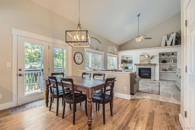 10155 Silver Maple Cir, Highlands Ranch, CO 80129 - dining room with high vaulted ceiling, light wood-style floors, plenty of natural light, and a brick fireplace