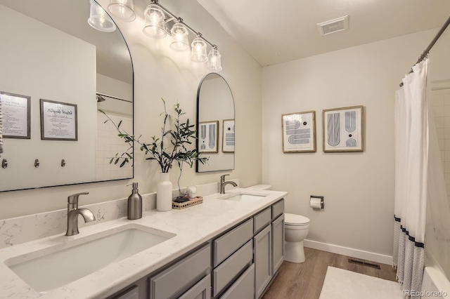 10155 Silver Maple Cir, Highlands Ranch, CO 80129 - full bathroom featuring wood finished floors, double vanity, toilet, curtained shower, and baseboards