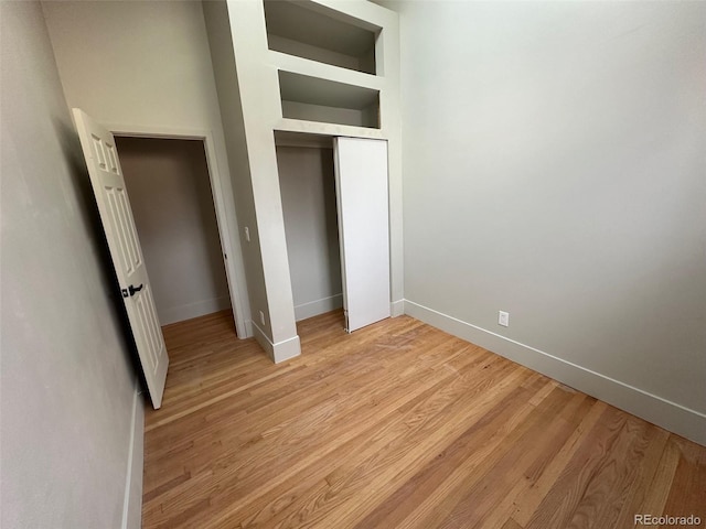 unfurnished bedroom featuring light hardwood / wood-style floors and a closet