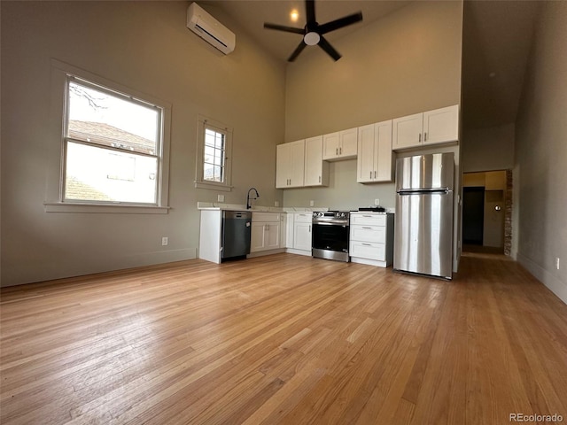 26 E Jewell Ave, Denver, CO 80210 - kitchen with a wall mounted AC, appliances with stainless steel finishes, white cabinets, light countertops, and a towering ceiling