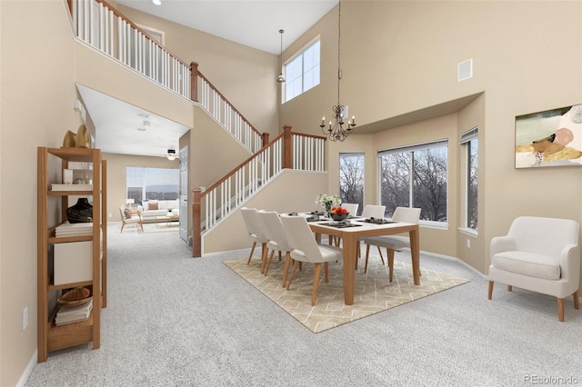 dining space with carpet, a high ceiling, and an inviting chandelier