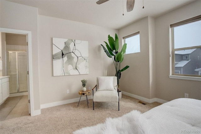 bedroom with ceiling fan, light colored carpet, and connected bathroom