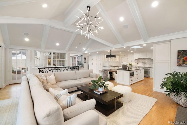 living room featuring a notable chandelier, vaulted ceiling with beams, and light hardwood / wood-style floors