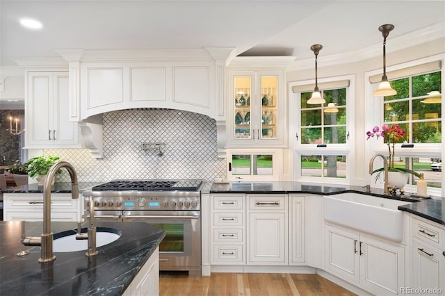 kitchen featuring sink, white cabinets, and range with two ovens