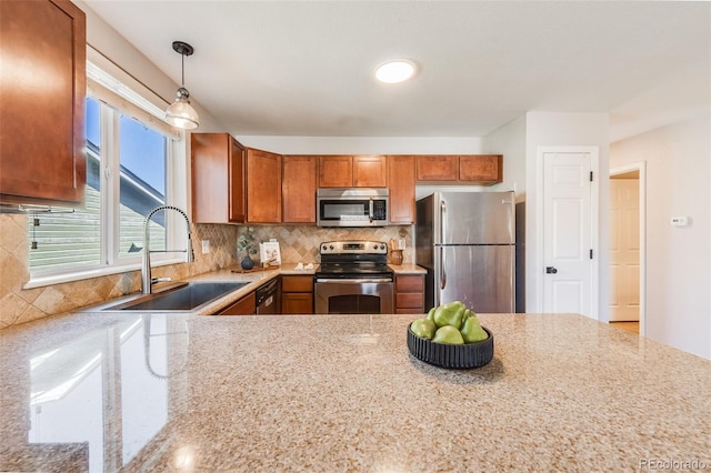 kitchen with stainless steel appliances, tasteful backsplash, sink, and decorative light fixtures