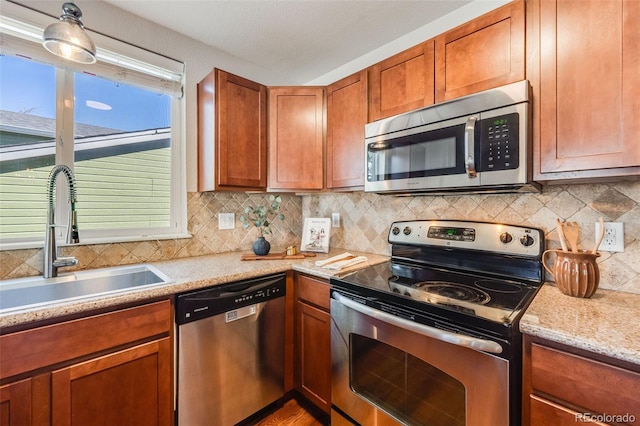 kitchen featuring appliances with stainless steel finishes, sink, light stone counters, and decorative backsplash