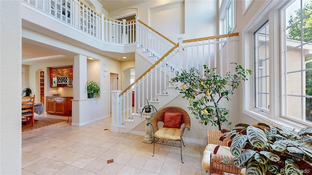interior space featuring tile patterned floors, baseboards, and a towering ceiling