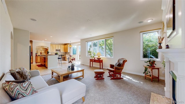 living area with baseboards, recessed lighting, plenty of natural light, and a fireplace with flush hearth