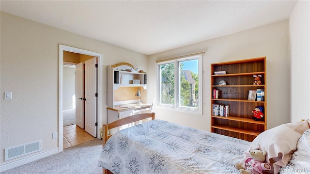 carpeted bedroom featuring tile patterned flooring and visible vents