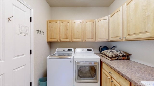 laundry room with independent washer and dryer and cabinet space