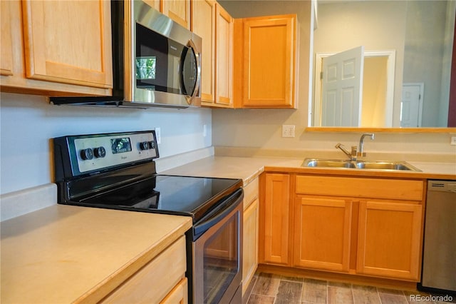 kitchen with a sink, light countertops, light brown cabinets, and stainless steel appliances