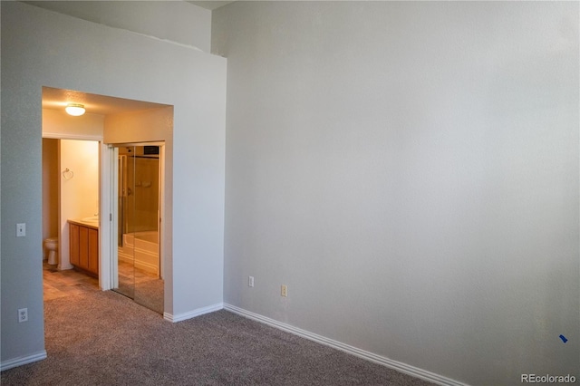 unfurnished bedroom featuring ensuite bath, baseboards, and carpet floors