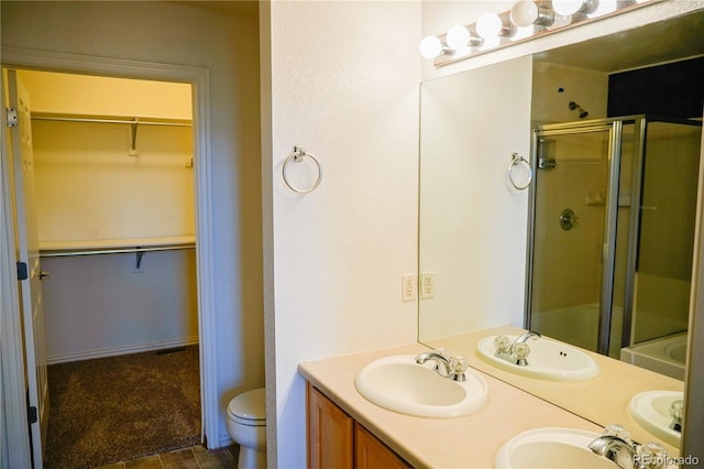 bathroom with a shower stall, a sink, and toilet