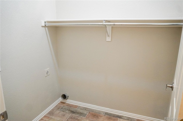 washroom featuring hookup for an electric dryer, laundry area, and baseboards