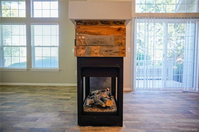 interior details with baseboards, a multi sided fireplace, and wood finished floors