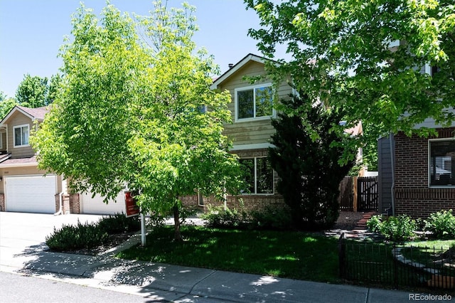 view of property hidden behind natural elements featuring a garage and a front lawn