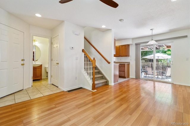 unfurnished living room featuring ceiling fan and light wood-type flooring