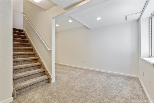 basement with a healthy amount of sunlight and carpet flooring