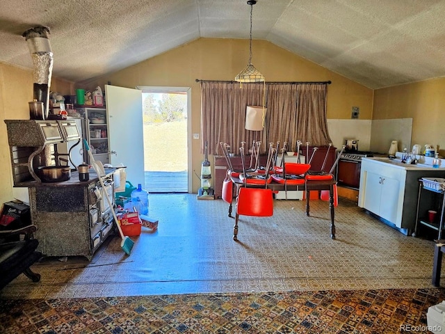 dining area featuring a textured ceiling and lofted ceiling