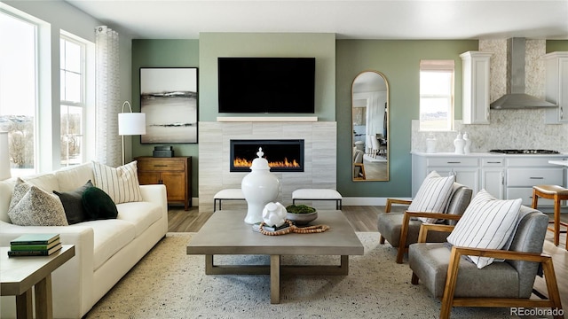 living room featuring light hardwood / wood-style flooring and a tiled fireplace