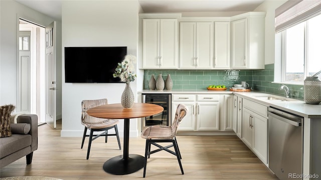 kitchen with wine cooler, dishwasher, sink, and white cabinetry