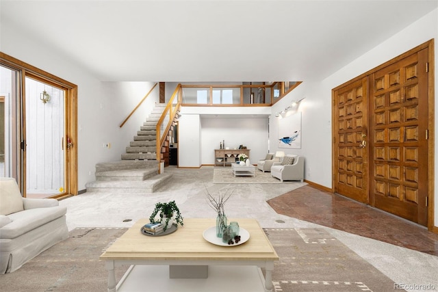 foyer entrance with stairs and baseboards