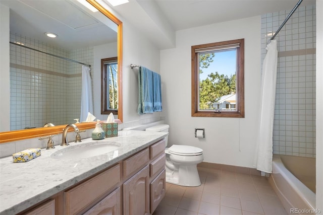 bathroom with toilet, plenty of natural light, vanity, and tile patterned floors