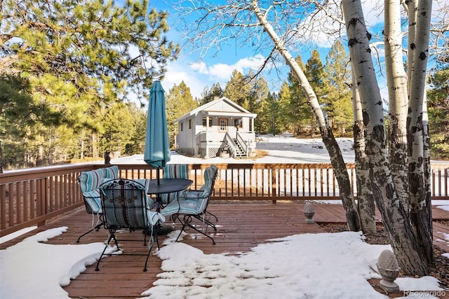 snow covered deck featuring outdoor dining area