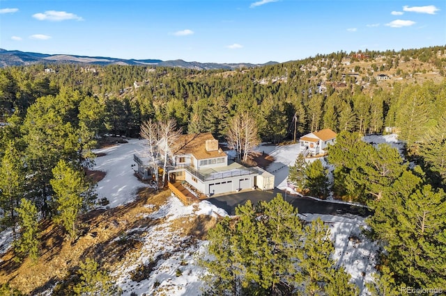 aerial view featuring a wooded view and a mountain view