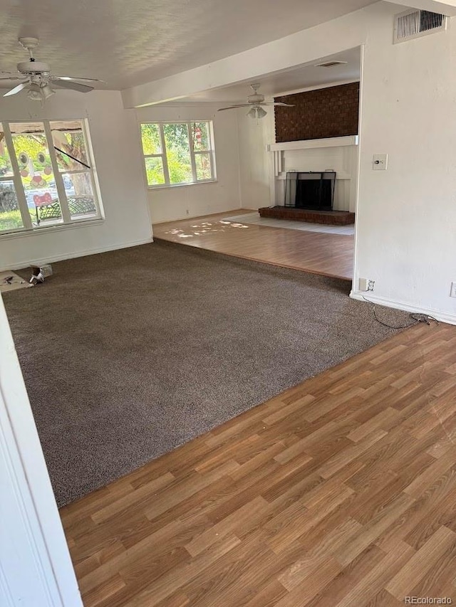 938 Salem St, Aurora, CO 80011 - unfurnished living room featuring ceiling fan, wood finished floors, a fireplace with raised hearth, and baseboards