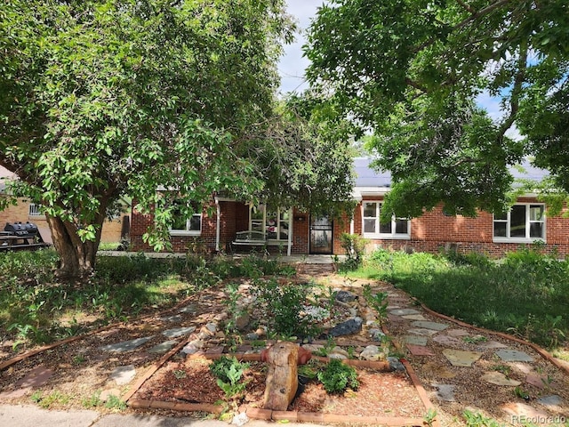 938 Salem St, Aurora, CO 80011 - view of property hidden behind natural elements featuring brick siding
