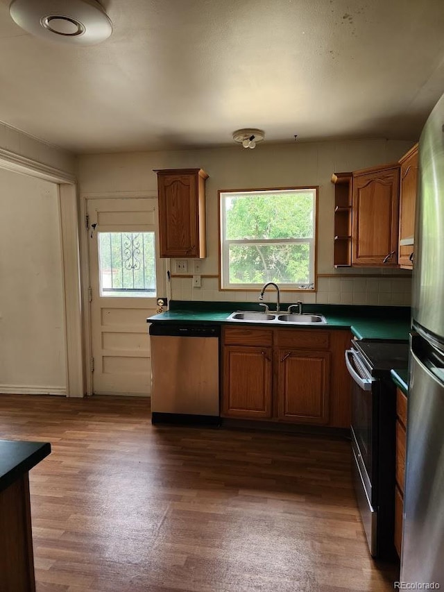938 Salem St, Aurora, CO 80011 - kitchen with stainless steel appliances, dark countertops, dark wood finished floors, and brown cabinetry