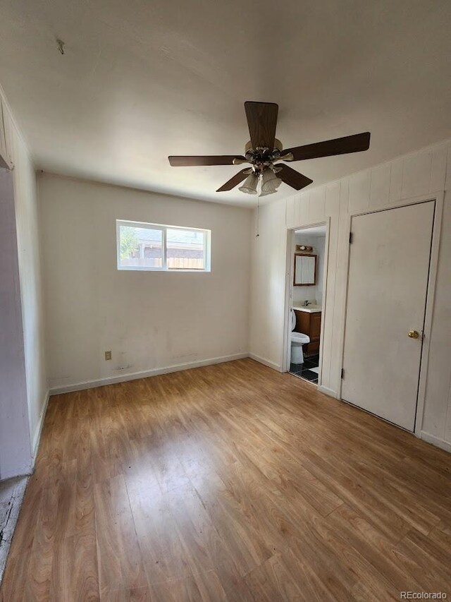 938 Salem St, Aurora, CO 80011 - unfurnished bedroom featuring wood finished floors, ensuite bath, and ceiling fan