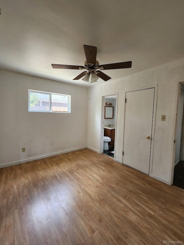 938 Salem St, Aurora, CO 80011 - unfurnished bedroom with wood finished floors, ensuite bath, and ceiling fan