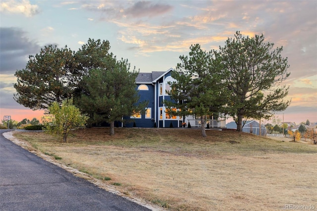 view of front of house with a yard and fence