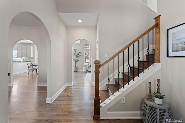 interior space with a high ceiling, wood finished floors, and baseboards