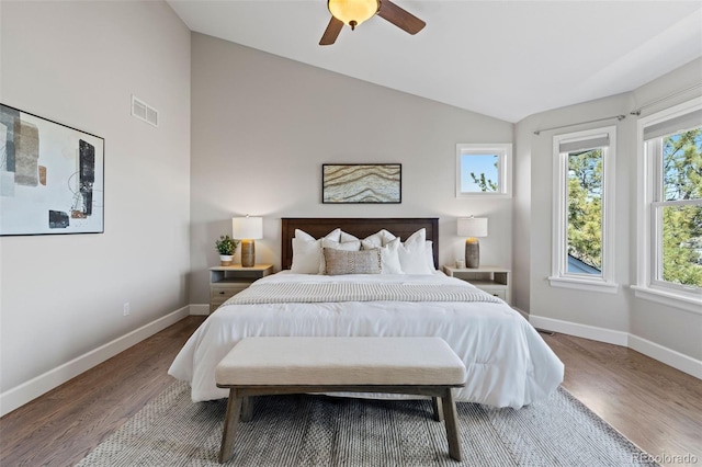 bedroom featuring visible vents, a ceiling fan, vaulted ceiling, wood finished floors, and baseboards