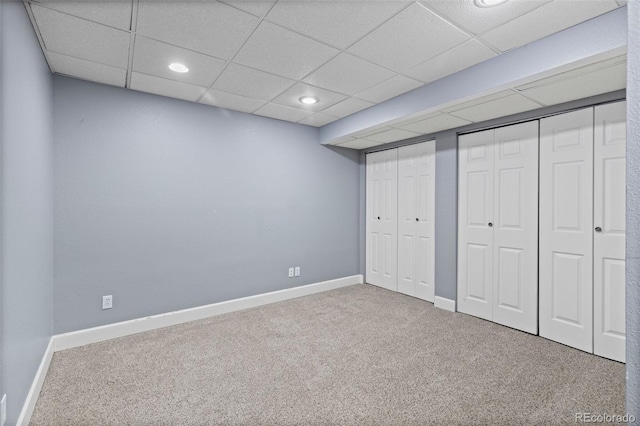 unfurnished bedroom featuring recessed lighting, carpet flooring, baseboards, and two closets