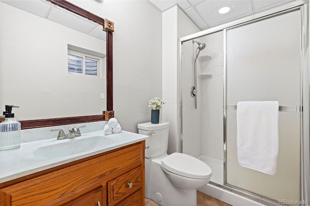 bathroom featuring toilet, a shower stall, and vanity