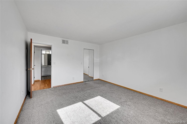 420 Zang St Unit 108, Lakewood, CO 80228 - unfurnished bedroom featuring baseboards, carpet flooring, visible vents, and ensuite bath