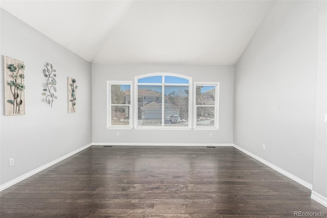 spare room featuring lofted ceiling and dark wood-type flooring