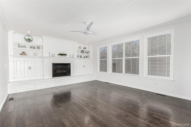 unfurnished living room featuring dark hardwood / wood-style flooring, crown molding, built in features, and ceiling fan