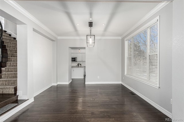 unfurnished living room featuring dark wood-type flooring and ornamental molding