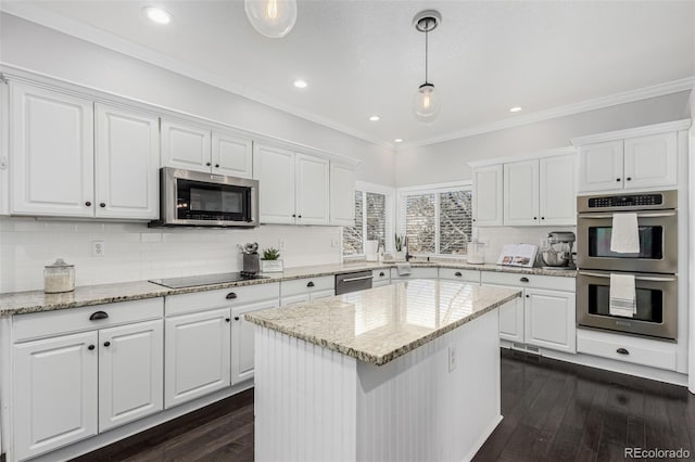 kitchen with a kitchen island, white cabinetry, appliances with stainless steel finishes, and decorative light fixtures