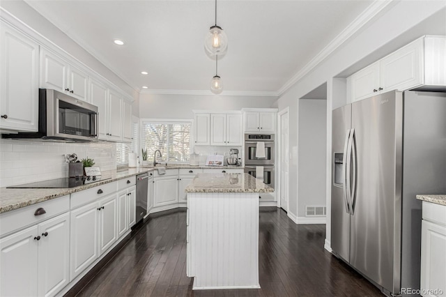 kitchen with pendant lighting, white cabinetry, a kitchen island, and appliances with stainless steel finishes