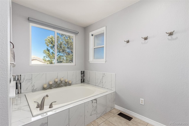 bathroom with tile patterned floors and tiled bath