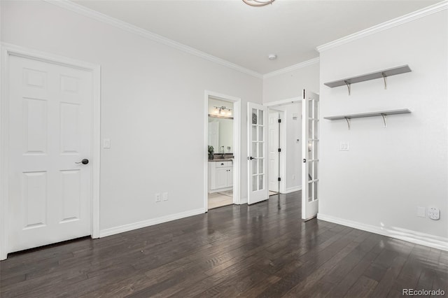 unfurnished bedroom featuring ensuite bathroom, dark wood-type flooring, crown molding, and french doors